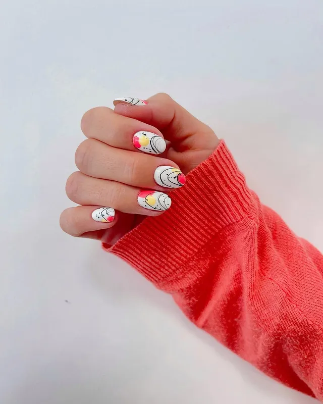 Uñas blancas con línea abstracta y toques pastel, diseño de Manicuí
