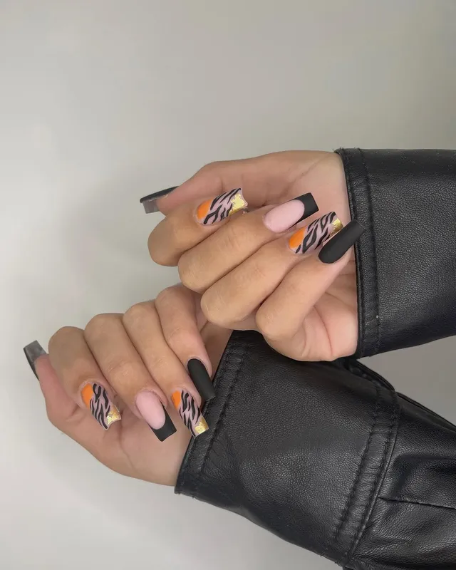 Uñas con estampado de tigre en naranja y foil dorado, hechas en Manicuí